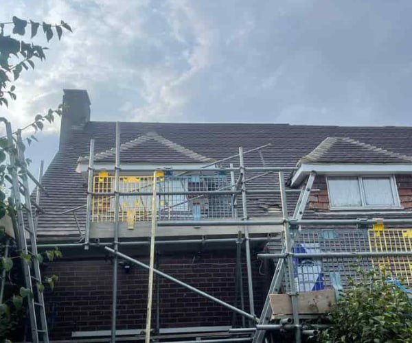 This is a photo of a roof with two dormers that is having some damaged tiles replaced. Works carried out by KJI Roofing Rothwell